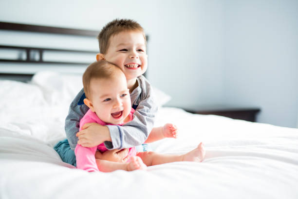 baby and his brother on bed baby and his brother on bed sister stock pictures, royalty-free photos & images