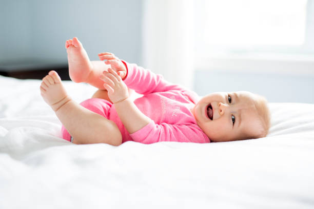 istock baby girl lying on white sheet 854143294