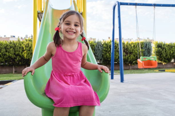 little girl playing at playground outdoors in summer - enjoyment spring park small imagens e fotografias de stock