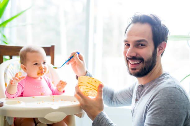 istock father feeding his little baby daughter 854152530