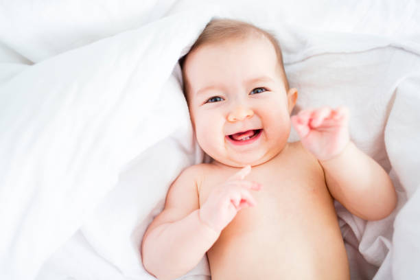 istock baby girl lying on white sheet 854155178