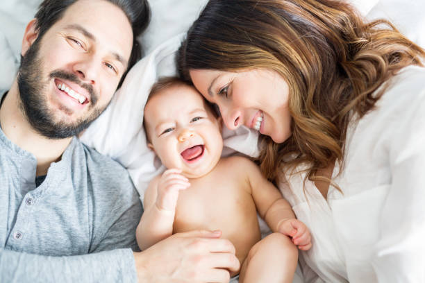 mãe do filho de pai e filho em uma cama branca - baby cheerful child blanket - fotografias e filmes do acervo