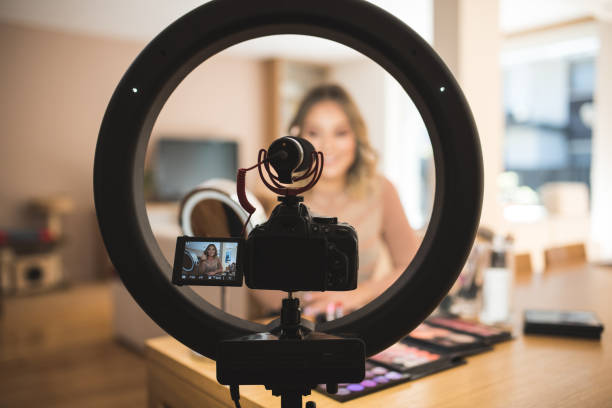 vlogger haciendo maquillaje - red lipstick fotografías e imágenes de stock