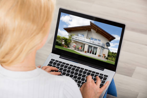 istock Woman Looking At House On Laptop's Screen 854170548