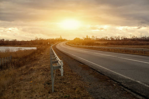 istock Empty asphalt road with near the lake with cloudy sky in evening light 854175798
