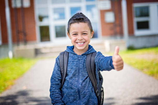 student outside school standing smiling A student boy outside at school standing and smiling 6 7 years stock pictures, royalty-free photos & images