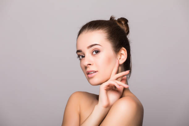 istock Beautiful woman face close up hand touching face studio on gray 854179688