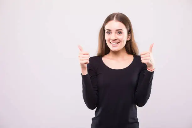 Photo of Portrait of beautiful woman with thumbs up sign on white