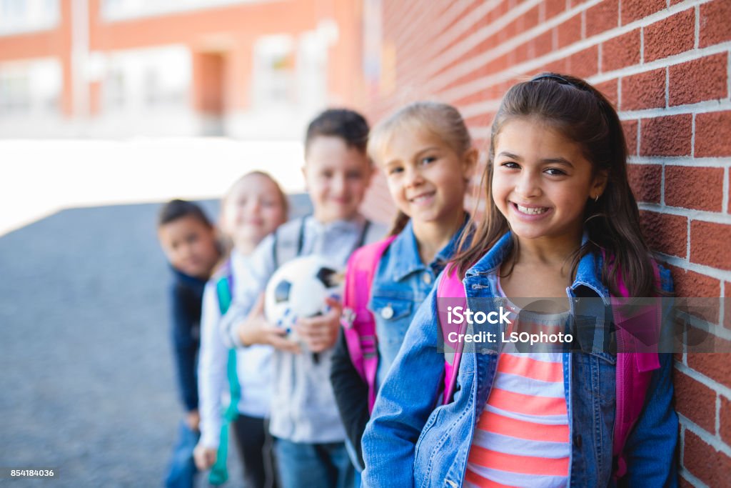 estudiantes fuera de la escuela de pie juntos - Foto de stock de Niño libre de derechos