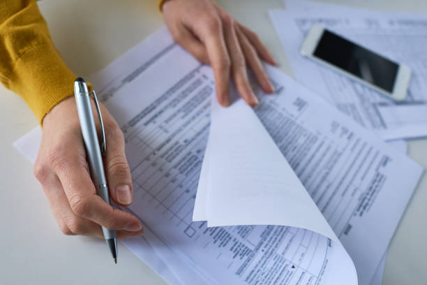 istock Woman examining financial papers 854191086