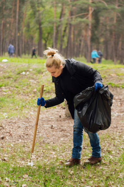 voluntaria recogiendo basura en el parque de la mujer - wastepaper basket fotografías e imágenes de stock