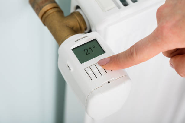 istock Person Adjusting Temperature On Thermostat 854202668