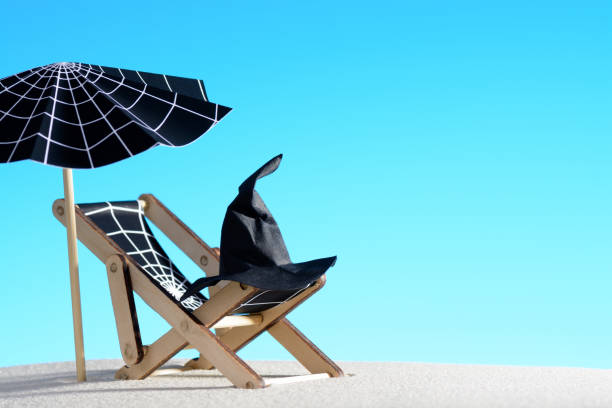 Lounge chair and umbrella with spider web on sand