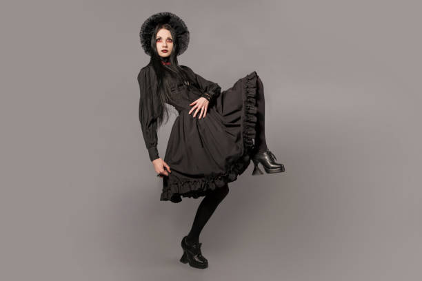 retrato de mulher morena de vestido preto e clássico estilo gótico, com os olhos vermelhos em fundo cinza. conceito de halloween. - goth - fotografias e filmes do acervo