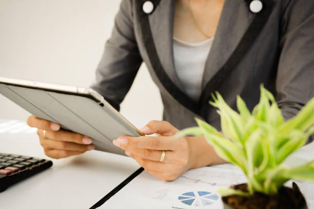 istock Businessman holding digital tablet at office on table with document graph data, Businesswoman calculate about cost, Finance managers task, Concept business and finance investment 854215182