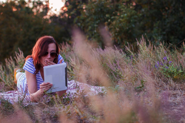 istock Young woman lying on a blanket with tablet 854215484