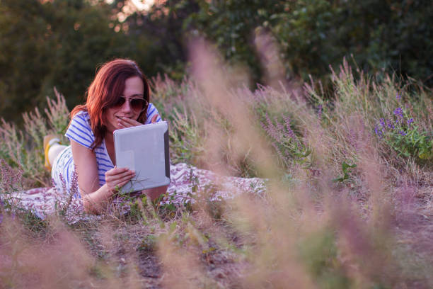 istock Young woman lying on a blanket with tablet 854215596