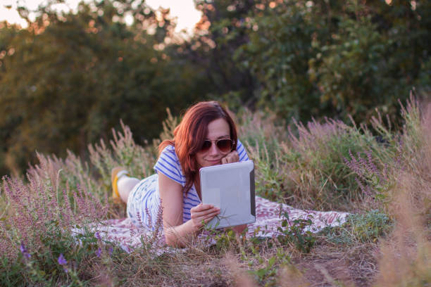 istock Young woman lying on a blanket with tablet 854215710