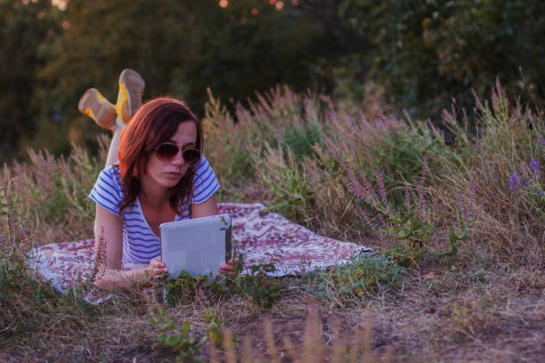 istock Young woman lying on a blanket with tablet 854216124
