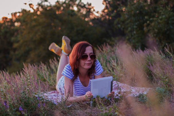istock Young woman lying on a blanket with tablet 854216240