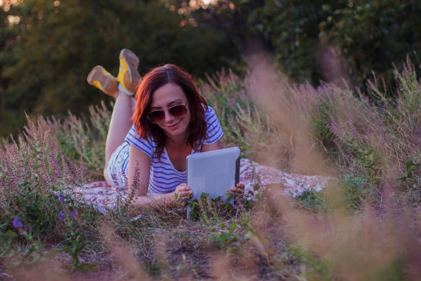 istock Young woman lying on a blanket with tablet 854216404