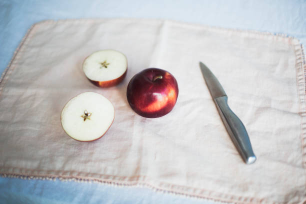 pommes rouges sur une table avec un couteau - doily freshness raw sweet food photos et images de collection