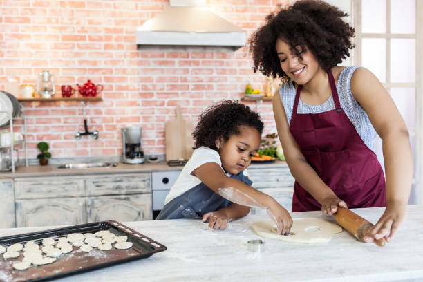 istock Mother and daughter using metal molds for making homemade biscuits 854219732