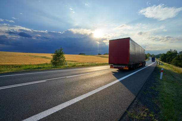 istock Trucks on the road at sunset with storm cloud 854222854