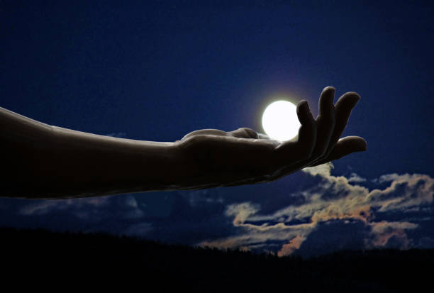istock Hand holding the moon in lighted sky 854222910