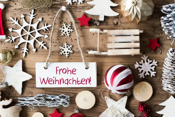 Signboard With German Text Frohe Weihnachten Means Merry Christmas. Christmas Decoration Like Sled, Ball, Christmas Tree And Snowflake. Brown Rustic Woodn Background. Natural Style