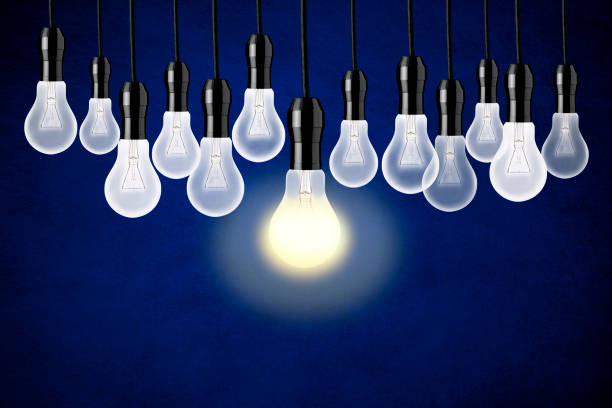 istock Lots of light bulbs hanging against blue background 854229926