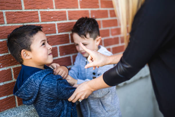 istock Teacher Stopping Two Boys Fighting In Playground 854244098