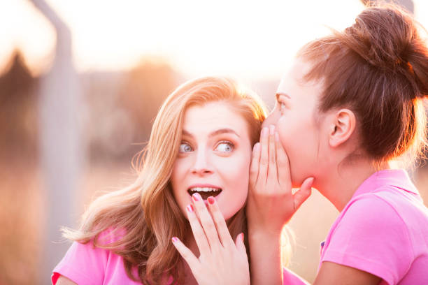 istock Two young woman gossiping 854250752