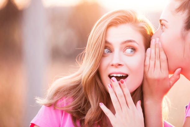istock Two young woman gossiping 854250756