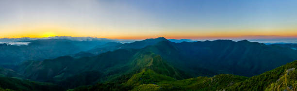 istock The panoramic view of mountain ridge, its range is the middle with slope down to valley on beside. The orange shade of sunrise color is show up horizontally along the sky of Doi Phu Wae, Nan, Thailan 854258274