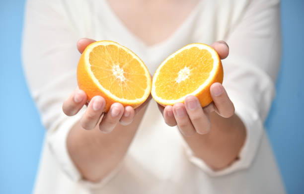 istock Woman hands holding sliced orange. 854269788