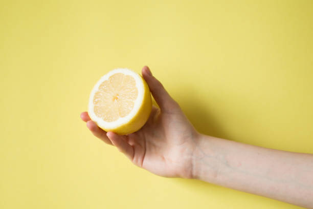 istock Lemon in woman's hand on a yellow background 854288196