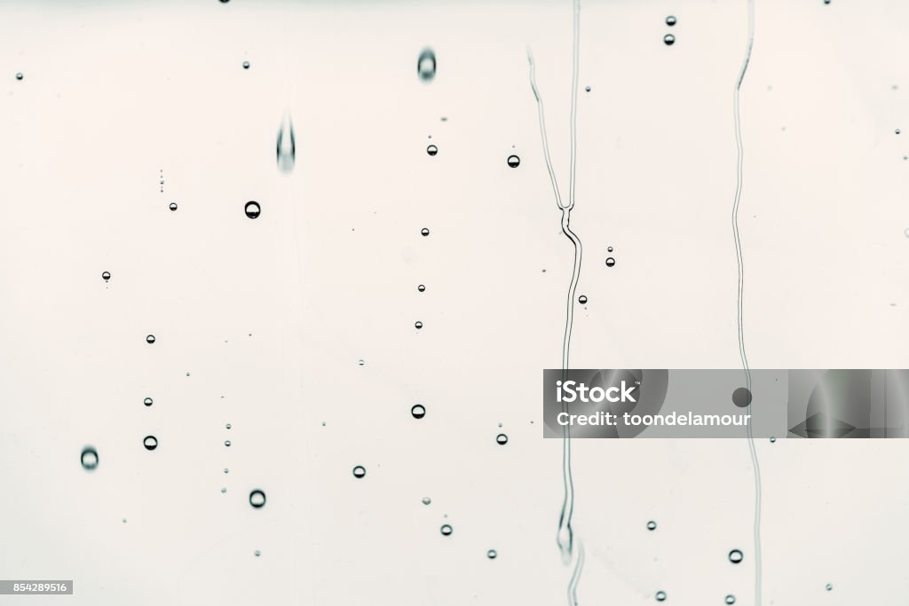 Gotas de chuva sobre vidro água flui, plano de fundo é de cor preta, foco seletivo. - Foto de stock de Gota - Líquido royalty-free