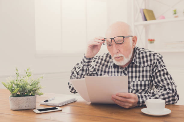 istock Shocked senior man looking at bills copy space 854292066