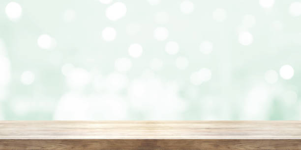 istock Empty wooden table top with blurred light green natural abstract background. Panoramic banner. Can be used product display. 854292758