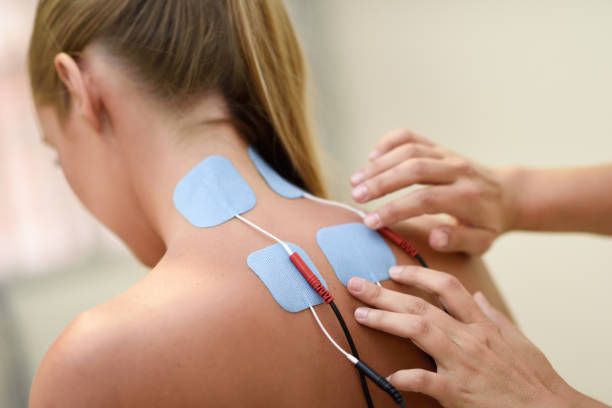 Electro stimulation in physical therapy to a young woman Electro stimulation in physical therapy to a young woman. Medical check at the shoulder in a physiotherapy center. electrode stock pictures, royalty-free photos & images