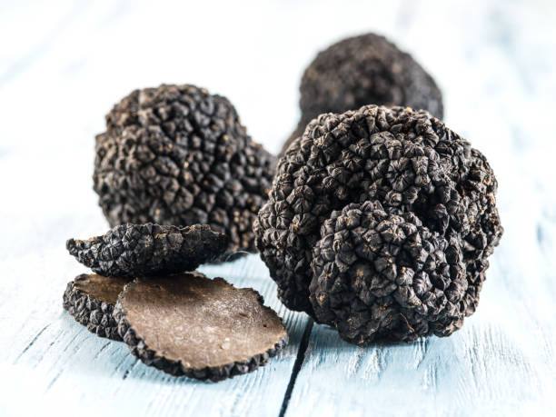 istock Black truffles on the old wooden table. 854293648