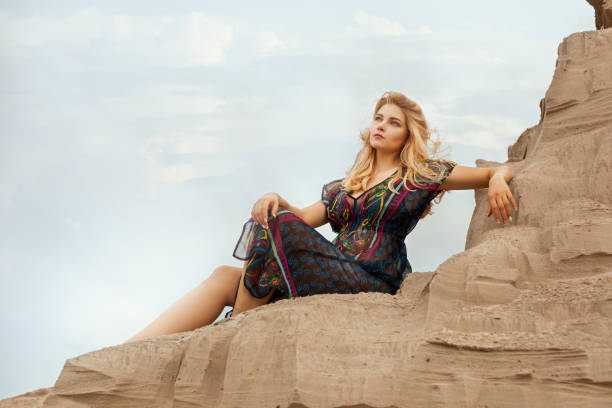 Woman is high on a sand dune from the desert.
