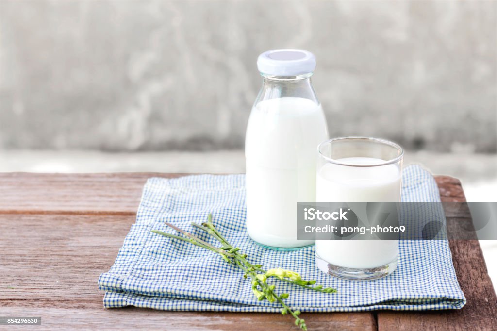 glass of milk and bottle of milk on the wood table. glass of milk and bottle of milk on the wood table. with copy space for text. Milk Stock Photo
