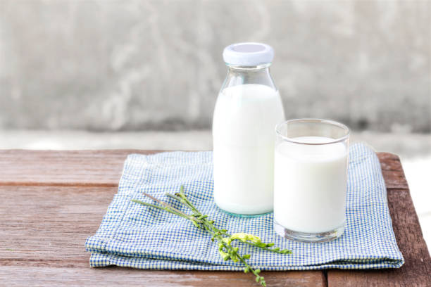 glass of milk and bottle of milk on the wood table. - leite imagens e fotografias de stock