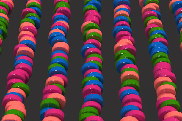istock Pattern of blue, red and green cylinder tablets on black background 854297432