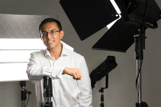 istock Man in Long Sleeve Shirt Surrounded by Studio Lighting Equipment 854299996