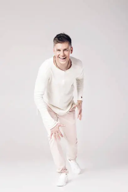 Photo of handsome young man in a white sweater and pants