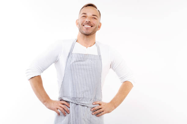 istock Pleasant man in apron holding hands on waist 854300384