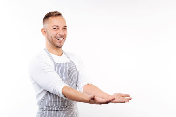istock Smiling man in apron stretching out his hands 854300562